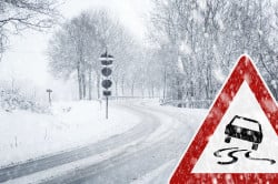 Besneeuwde bochtige weg met verkeersbord