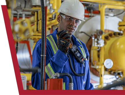 Een werknemer in de olie- en gasindustrie die de RSM-microfoon van Blackline Safety gebruikt om met zijn team te communiceren.