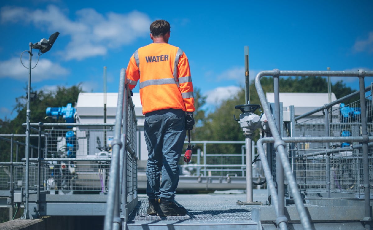 Een alleenwerkende medewerker buiten bij de Wessex Water-fabriek in West-Engeland, Verenigd Koninkrijk.